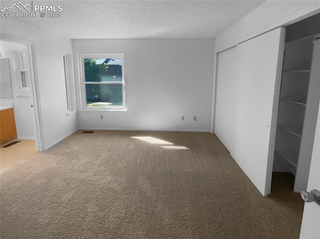 937 Moorings Dr, Colorado Springs, CO 80906 - unfurnished bedroom with light carpet, a closet, refrigerator, a textured ceiling, and ensuite bath