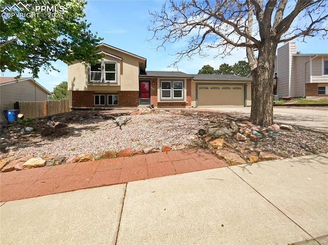 8193 Horizon Dr, Colorado Springs, CO 80920 - tri-level home featuring brick siding, an attached garage, and driveway