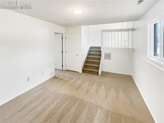 8193 Horizon Dr, Colorado Springs, CO 80920 - unfurnished room with carpet floors, stairs, a textured ceiling, and baseboards