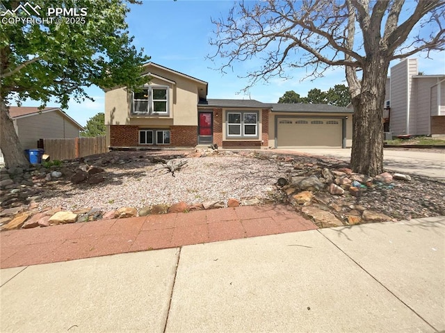 8193 Horizon Dr, Colorado Springs, CO 80920 - split level home featuring brick siding, a garage, concrete driveway, and stucco siding