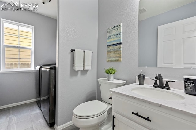 14213 Woodrock Path, Colorado Springs, CO 80921 - bathroom with separate washer and dryer, vanity, toilet, baseboards, and tile patterned flooring