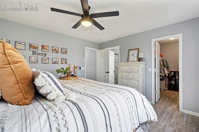 14213 Woodrock Path, Colorado Springs, CO 80921 - bedroom with a spacious closet, wood finished floors, ceiling fan, a closet, and baseboards