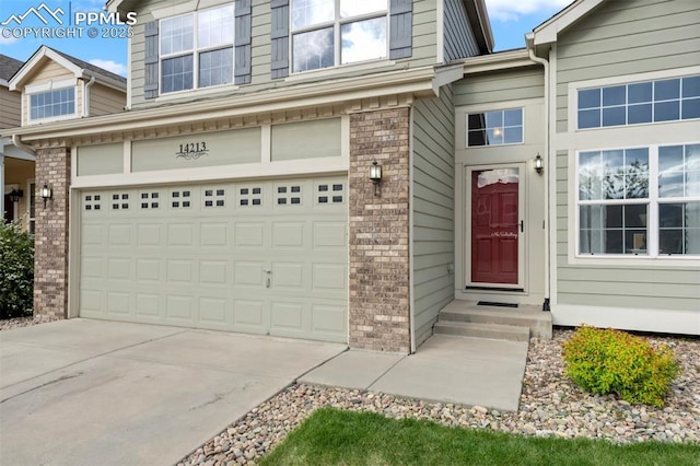 14213 Woodrock Path, Colorado Springs, CO 80921 - view of exterior entry with a garage, brick siding, and concrete driveway