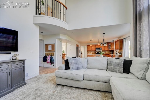 10368 Mount Evans Dr, Peyton, CO 80831 - living area with a high ceiling, light wood-style floors, and baseboards
