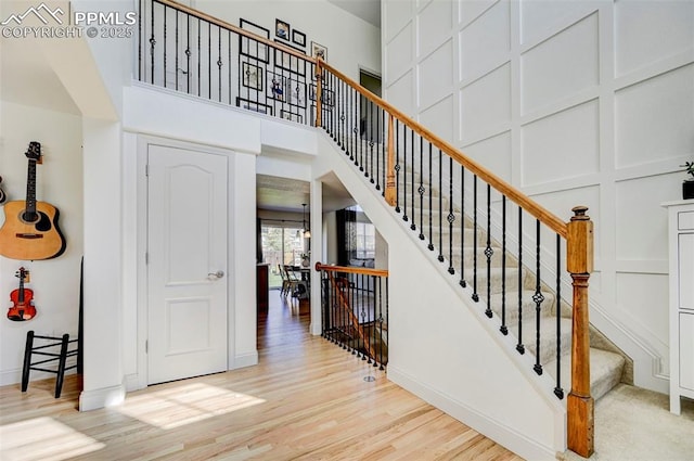 10368 Mount Evans Dr, Peyton, CO 80831 - stairs featuring wood finished floors, a high ceiling, and baseboards