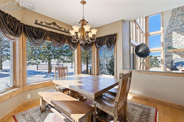 18320 Table Rock Rd, Colorado Springs, CO 80908 - dining space featuring baseboards, hardwood / wood-style floors, a chandelier, and healthy amount of natural light