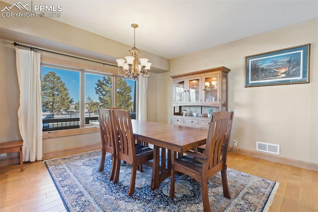 18320 Table Rock Rd, Colorado Springs, CO 80908 - dining room with a chandelier, light wood finished floors, and baseboards