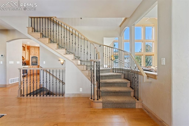 18320 Table Rock Rd, Colorado Springs, CO 80908 - stairs featuring hardwood / wood-style floors, arched walkways, and baseboards