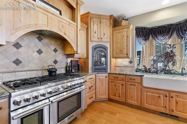18320 Table Rock Rd, Colorado Springs, CO 80908 - kitchen featuring range with two ovens, a sink, stone countertops, light wood-type flooring, and backsplash