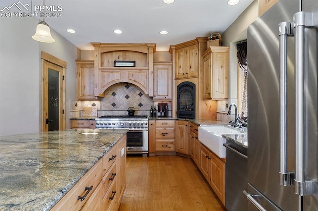 18320 Table Rock Rd, Colorado Springs, CO 80908 - kitchen featuring appliances with stainless steel finishes, a sink, backsplash, custom range hood, and recessed lighting