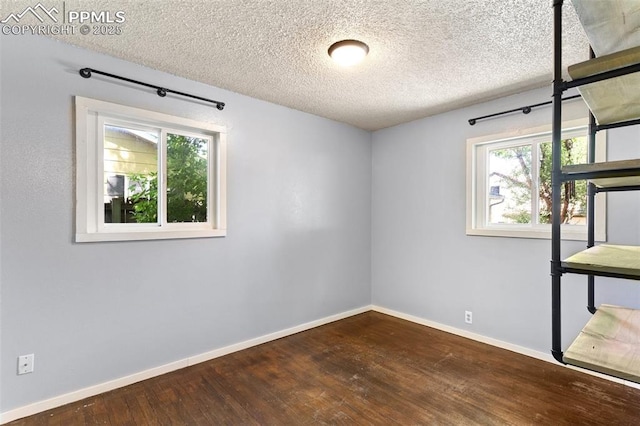 1004 Montrose Ave, Colorado Springs, CO 80905 - unfurnished bedroom with wood finished floors, baseboards, and a textured ceiling