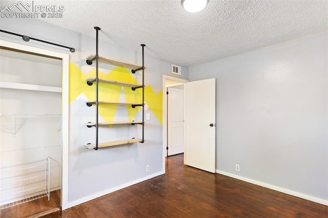 1004 Montrose Ave, Colorado Springs, CO 80905 - unfurnished bedroom featuring wood finished floors, a textured ceiling, baseboards, and a closet