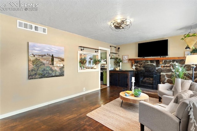 1004 Montrose Ave, Colorado Springs, CO 80905 - living room with wood finished floors, baseboards, a fireplace, and a textured ceiling