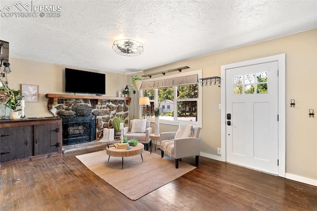 1004 Montrose Ave, Colorado Springs, CO 80905 - living room featuring wood finished floors, plenty of natural light, baseboards, a textured ceiling, and a stone fireplace