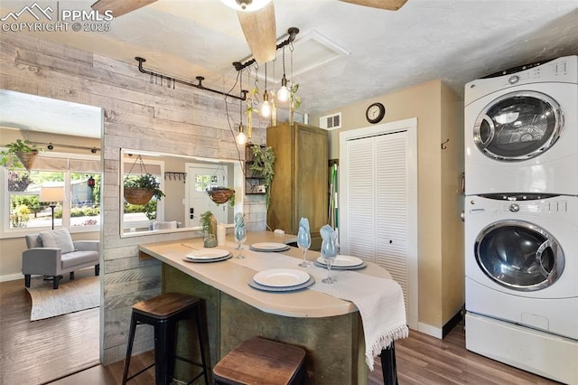 1004 Montrose Ave, Colorado Springs, CO 80905 - dining space with stacked washer and clothes dryer, baseboards, dark wood-type flooring, wooden walls, and attic access