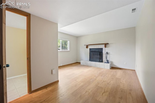 945 Bromefield Dr, Fountain, CO 80817 - unfurnished living room with a tile fireplace, wood finished floors, and baseboards