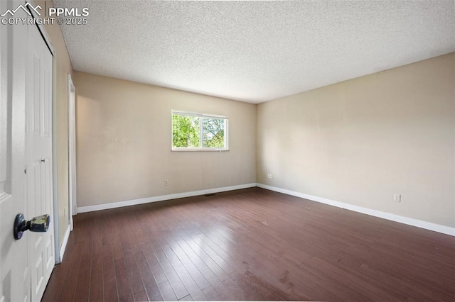 945 Bromefield Dr, Fountain, CO 80817 - unfurnished room featuring dark wood-style flooring, a textured ceiling, and baseboards