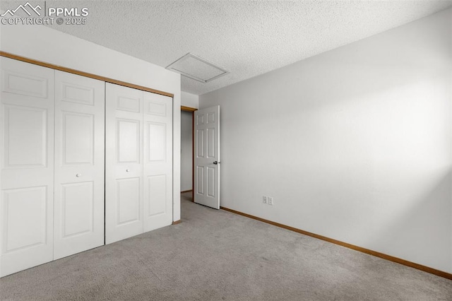 945 Bromefield Dr, Fountain, CO 80817 - unfurnished bedroom featuring attic access, carpet, a closet, a textured ceiling, and baseboards