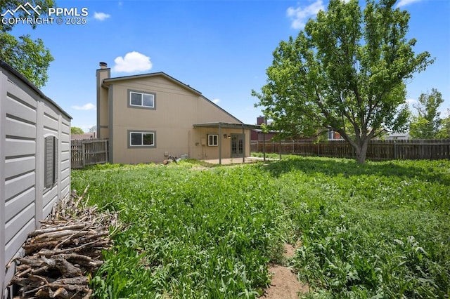945 Bromefield Dr, Fountain, CO 80817 - back of house featuring a fenced backyard, a patio area, and a chimney
