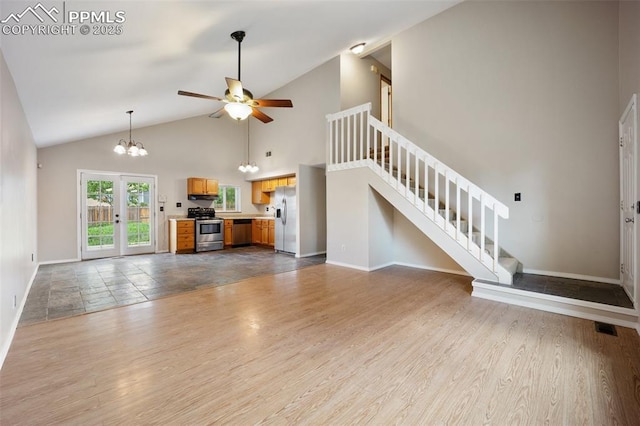945 Bromefield Dr, Fountain, CO 80817 - unfurnished living room featuring stairway, baseboards, ceiling fan, a chandelier, and high vaulted ceiling