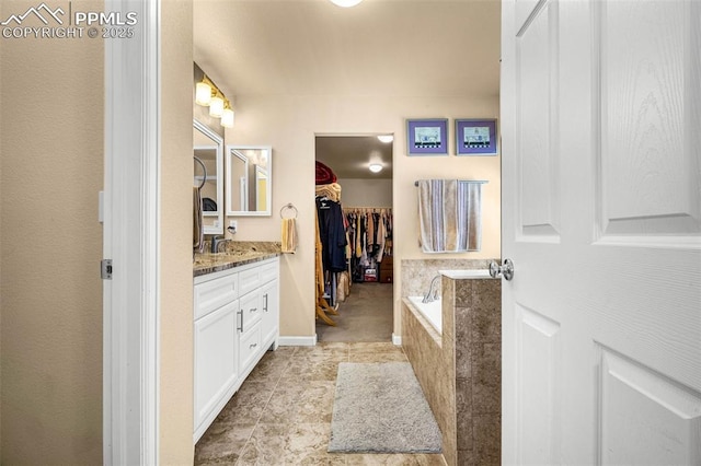 8004 Brittinger Way, Colorado Springs, CO 80951 - bathroom featuring vanity, a bath, a walk in closet, and baseboards