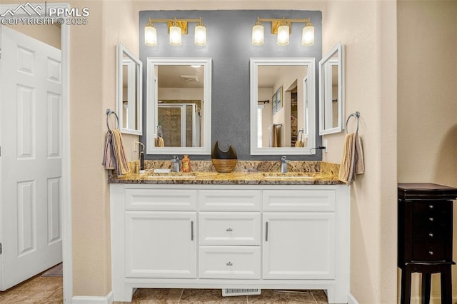 8004 Brittinger Way, Colorado Springs, CO 80951 - full bath featuring double vanity, a shower with shower door, baseboards, and tile patterned flooring
