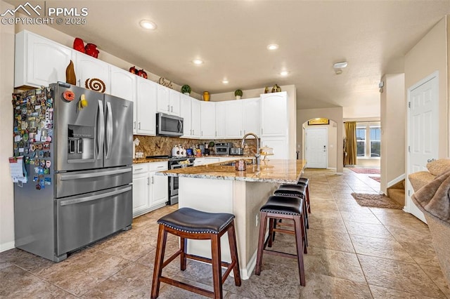 8004 Brittinger Way, Colorado Springs, CO 80951 - kitchen with stainless steel appliances, a sink, light stone countertops, tasteful backsplash, and white cabinetry