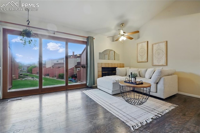 1225 Holland Park Blvd, Colorado Springs, CO 80907 - living room featuring a ceiling fan, a tiled fireplace, wood finished floors, and baseboards