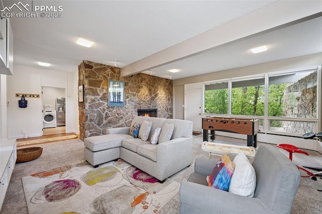 3 Heather Cir, Colorado Springs, CO 80906 - carpeted living room featuring washer / clothes dryer, a stone fireplace, and beam ceiling