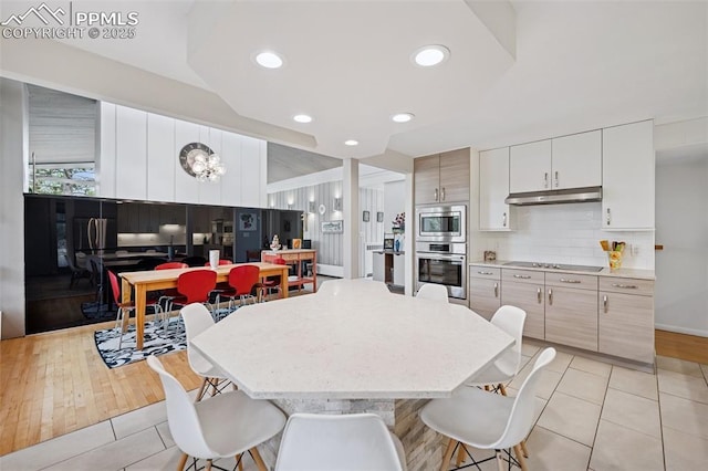 3 Heather Cir, Colorado Springs, CO 80906 - kitchen with appliances with stainless steel finishes, under cabinet range hood, light tile patterned floors, a breakfast bar area, and recessed lighting