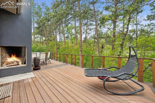 3 Heather Cir, Colorado Springs, CO 80906 - wooden terrace with an outdoor brick fireplace and outdoor dining area
