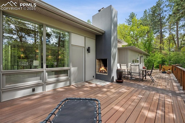3 Heather Cir, Colorado Springs, CO 80906 - wooden terrace featuring a warm lit fireplace and outdoor dining space