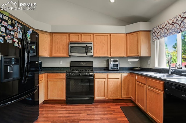 6557 Many Moon Dr, Colorado Springs, CO 80923 - kitchen featuring black appliances, a sink, vaulted ceiling, dark wood finished floors, and dark countertops