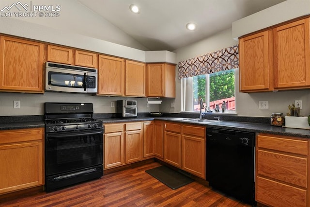 6557 Many Moon Dr, Colorado Springs, CO 80923 - kitchen with black appliances, a sink, vaulted ceiling, dark countertops, and dark wood-style flooring