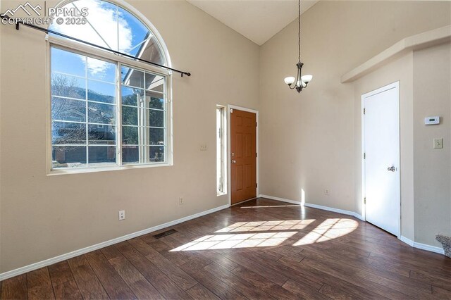 7435 Julynn Rd, Colorado Springs, CO 80919 - entrance foyer featuring a chandelier, wood finished floors, baseboards, and high vaulted ceiling