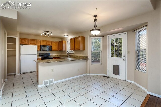7435 Julynn Rd, Colorado Springs, CO 80919 - kitchen featuring black appliances, a sink, a peninsula, light tile patterned floors, and decorative light fixtures