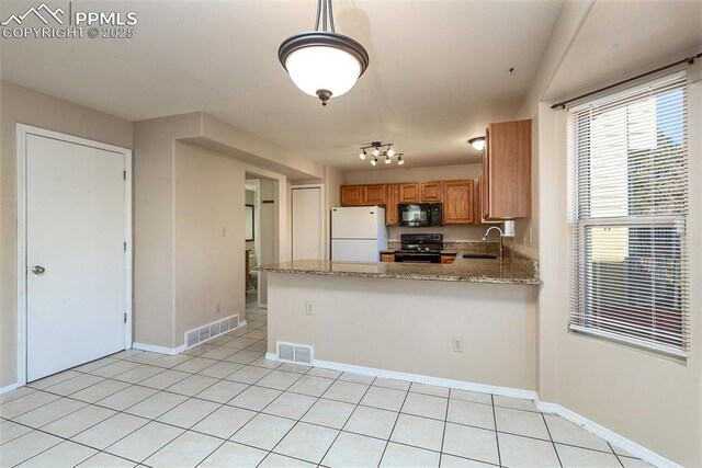7435 Julynn Rd, Colorado Springs, CO 80919 - kitchen with black appliances, a sink, a peninsula, baseboards, and light stone counters