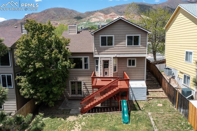 7435 Julynn Rd, Colorado Springs, CO 80919 - back of house with a playground, a patio area, a shingled roof, stairs, and a deck with mountain view