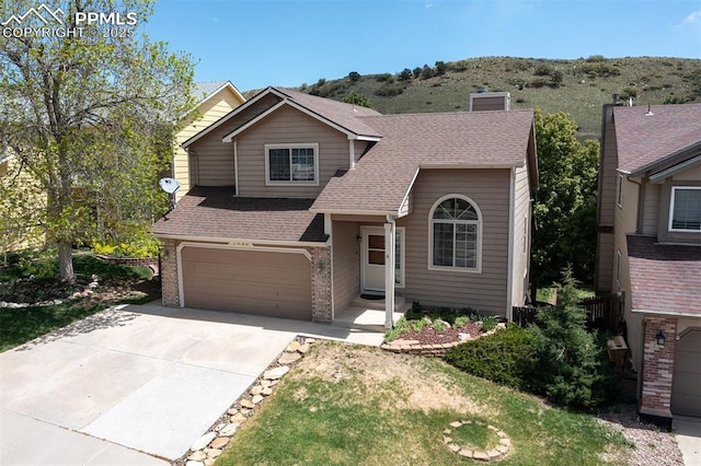 7435 Julynn Rd, Colorado Springs, CO 80919 - traditional home with a garage, brick siding, driveway, a chimney, and a shingled roof
