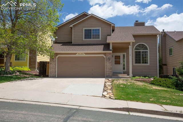 7435 Julynn Rd, Colorado Springs, CO 80919 - view of front of house featuring an attached garage, brick siding, driveway, a chimney, and roof with shingles