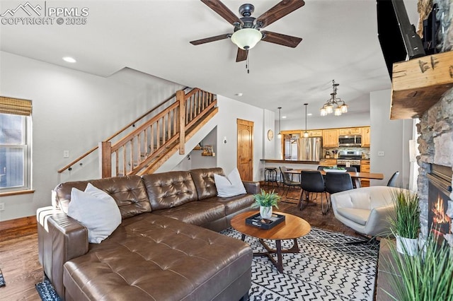 404 S Willow St, Woodland Park, CO 80863 - living room with stairway, ceiling fan, wood finished floors, a chandelier, and baseboards