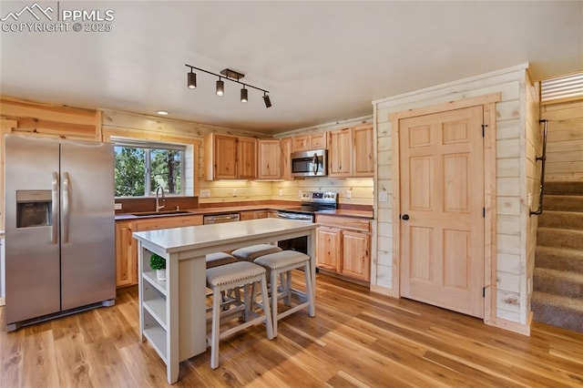 621 Yorktown Rd, Cripple Creek, CO 80863 - kitchen with stainless steel appliances, a sink, a kitchen bar, and light wood-style floors