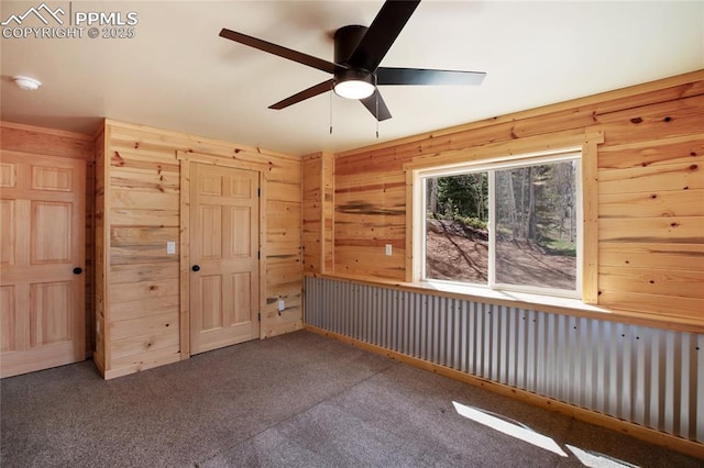 621 Yorktown Rd, Cripple Creek, CO 80863 - unfurnished bedroom featuring carpet floors, wooden walls, a closet, and ceiling fan