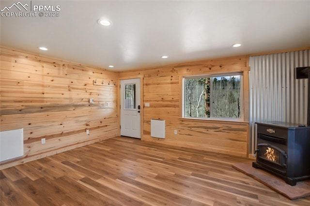 621 Yorktown Rd, Cripple Creek, CO 80863 - spare room featuring a wood stove, recessed lighting, wood finished floors, and wooden walls