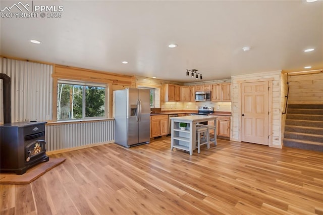 621 Yorktown Rd, Cripple Creek, CO 80863 - kitchen featuring stainless steel appliances, a wood stove, open shelves, light wood finished floors, and light brown cabinets