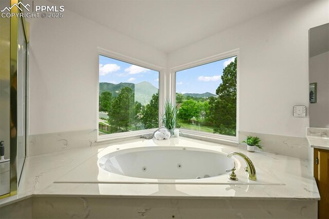 8110 Routt Ct, Colorado Springs, CO 80919 - full bathroom featuring vanity, a jetted tub, and a mountain view