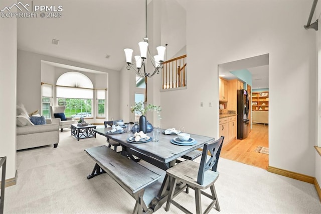 8110 Routt Ct, Colorado Springs, CO 80919 - dining area with high vaulted ceiling, light carpet, and a chandelier