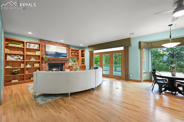 8110 Routt Ct, Colorado Springs, CO 80919 - living area with light wood finished floors, a fireplace, recessed lighting, a ceiling fan, and french doors