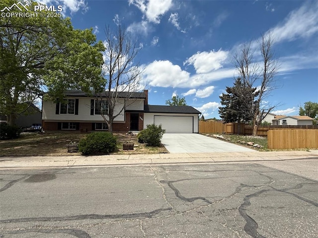 4770 Newton Dr, Colorado Springs, CO 80916 - split level home featuring driveway, an attached garage, and brick siding
