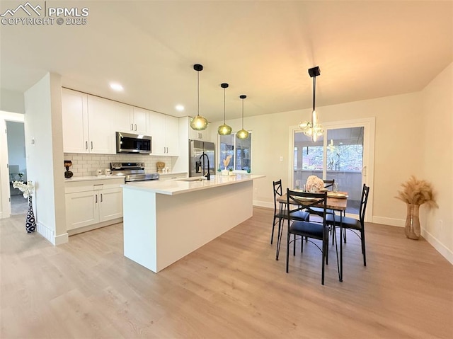 4770 Newton Dr, Colorado Springs, CO 80916 - kitchen with appliances with stainless steel finishes, a chandelier, a sink, light wood finished floors, and recessed lighting